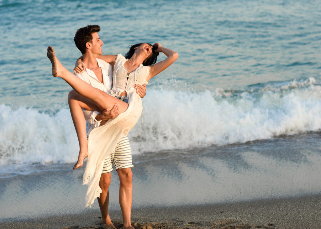 homme-qui-porte-sa-copine-dans-les-bras-au-bord-de-la-plage