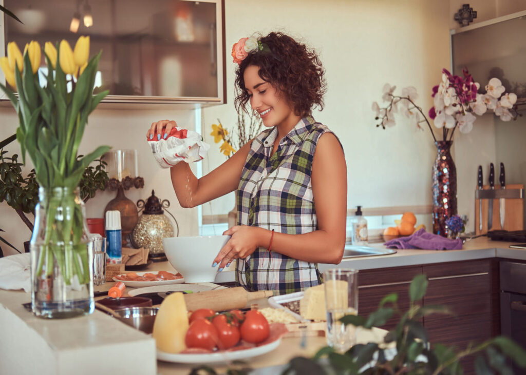 femme-souriante-en-train-de-cuisiner-dans-chez-elle