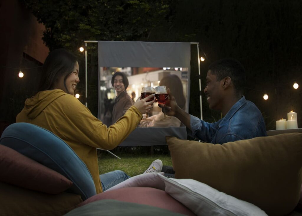 une-homme-et-une-femme-qui-trinque-leurs-verres-devant-un-film-projete-sur-une-toile