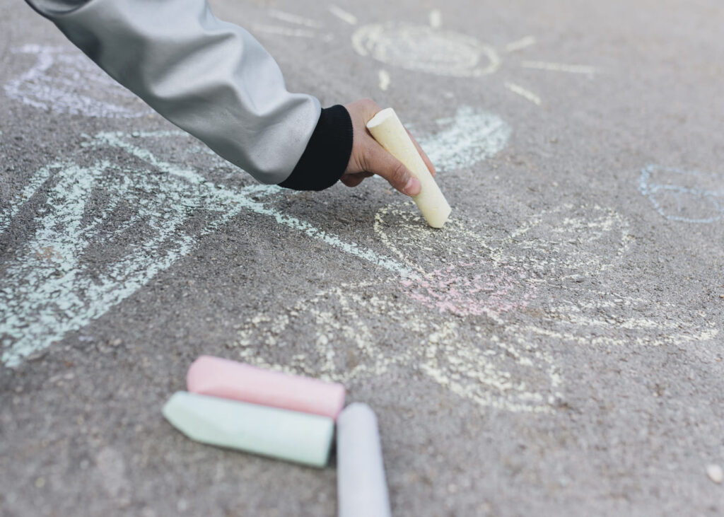 enfant-qui-dessine-a-la-craie-sur-un-trottoir
