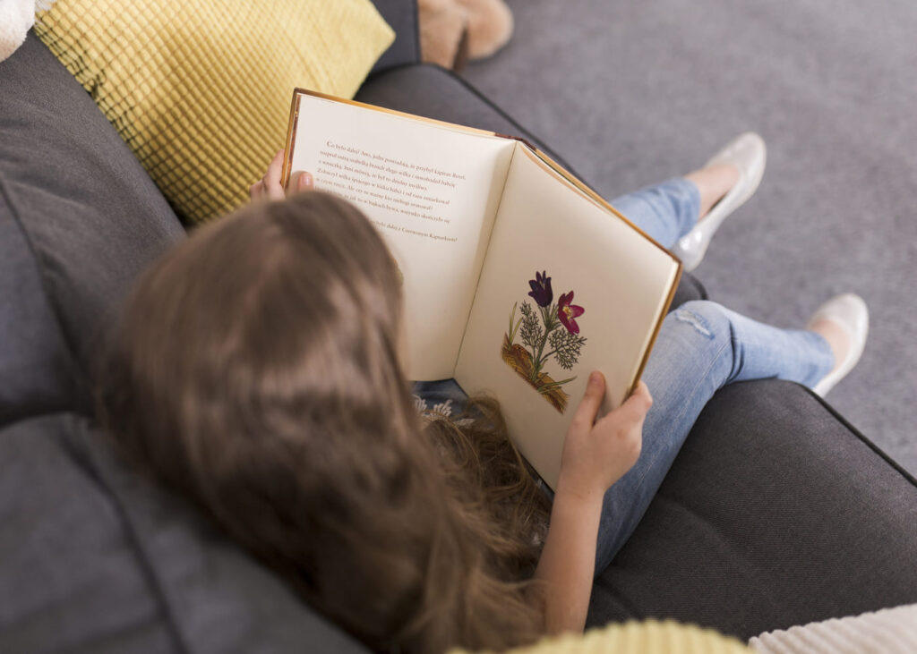 enfant-qui-lit-un-livre-sur-un-canape
