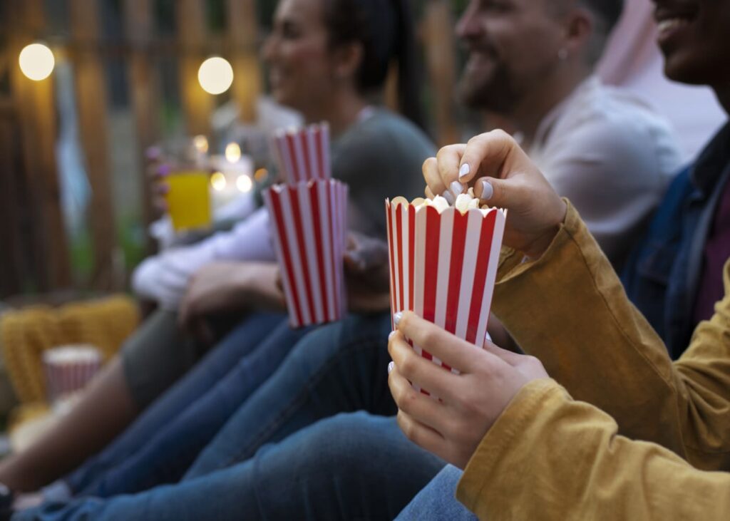 amis-qui-mangent-du-pop-corn-dans-un-cinema-en-plein-air