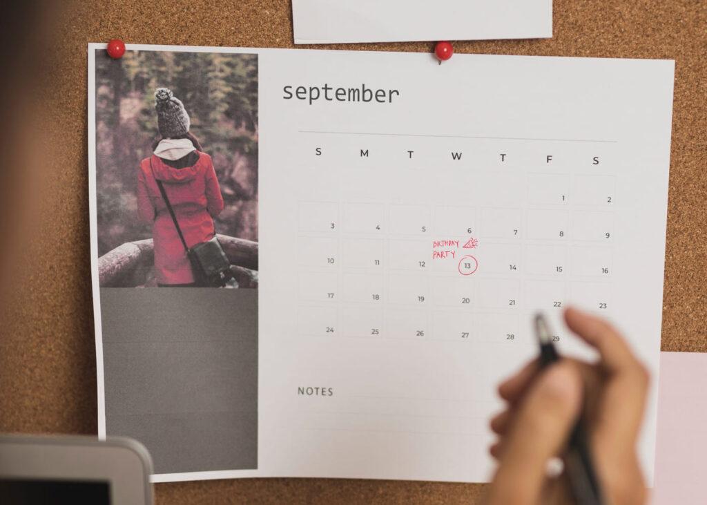 calendrier-photo-avec-une-main-qui-tient-un-stylo-et-qui-a-entoure-une-date-en-rouge