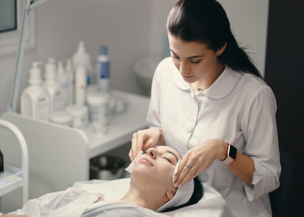 cosmetologue-qui-fait-un-soin-du-visage-a-sa-cliente-dans-son-cabinet.jpg