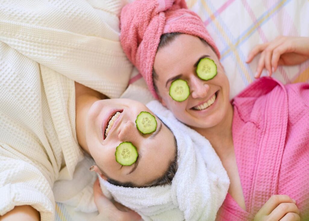 deux-copines-allongees-en-peignoir-avec-des-rondelles-de-concombre-sur-les-yeux