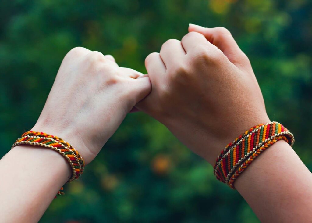 deux-personnes-qui-se-serrent-le-petit-doigt-avec-un-bracelet-de-l-amitie-a-chaque-poignet.jpg