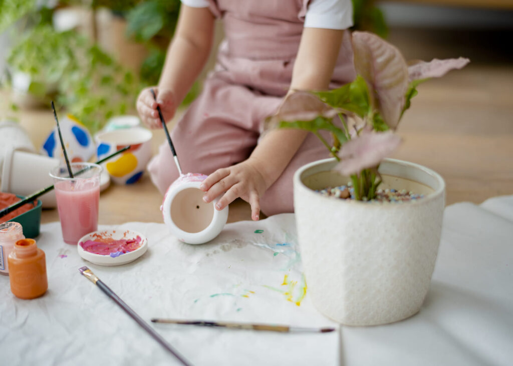 enfant-assis-par-terre-qui-fait-de-la-peinture-sur-un-pot-en-ceramique.jpg
