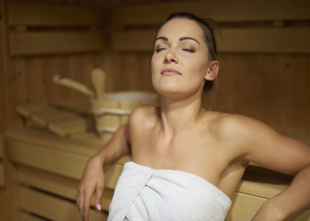femme-assise-dans-un-sauna-les-yeux-fermes
