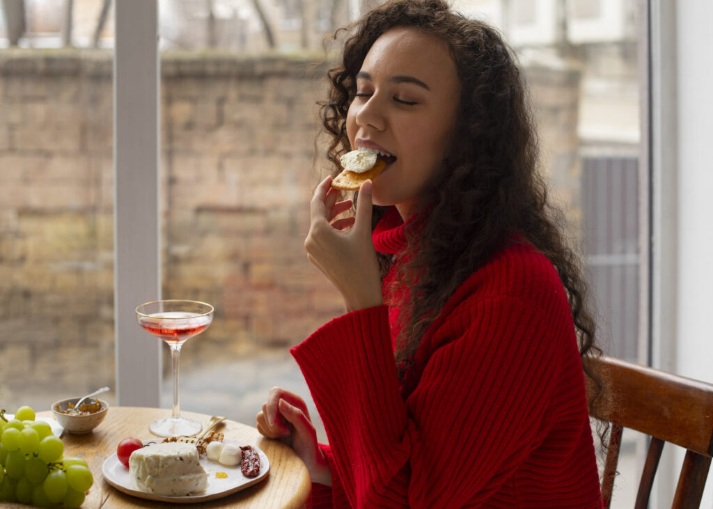 femme-qui-deguste-du-fromage-assise-a-une-table-les-yeux-fermes.jpg