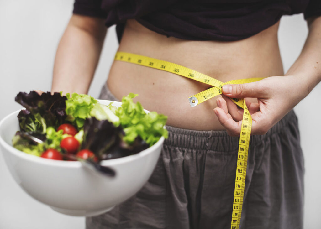 femme-qui-mesure-son-tour-de-taille-avec-une-salade-dans-la-main-.jpg