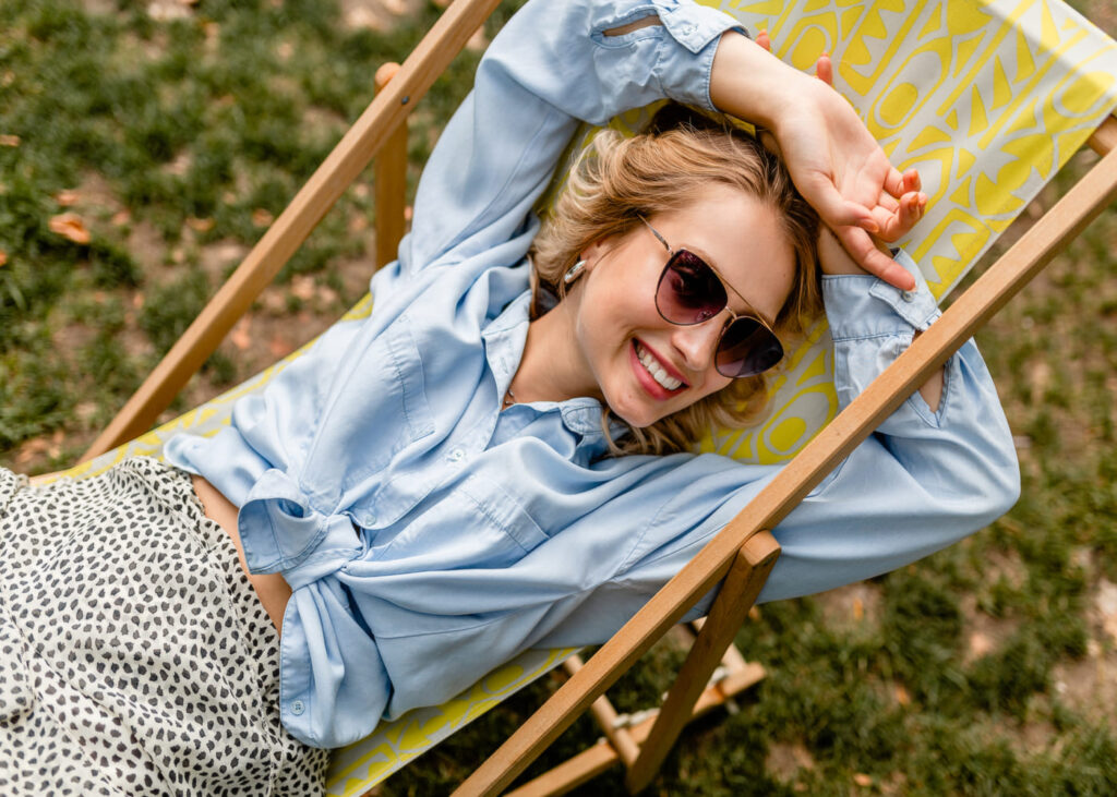 femme-qui-sourit-et-porte-des-lunettes-de-soleil-allongee-sur-un-transit