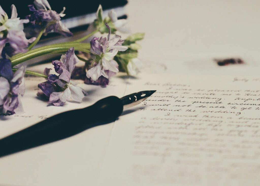 fleurs-et-stylo-plume-posés-sur-une-lettre-manuscrite