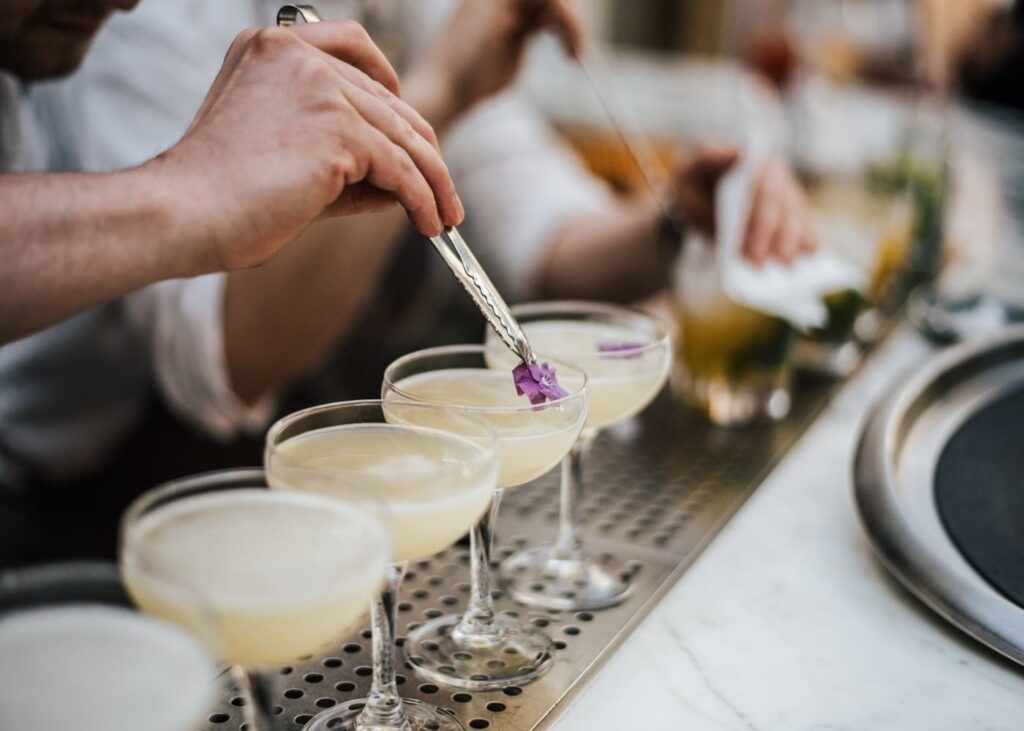 gros-plan-d-un-barman-qui-met-une-fleur-dans-un-cocktail