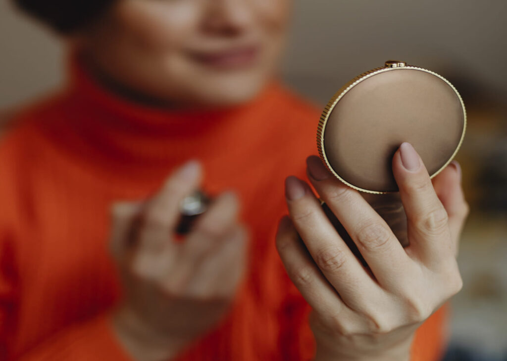 gros-plan-d-une-femme-qui-se-regarde-dans-un-miroir-de-poche