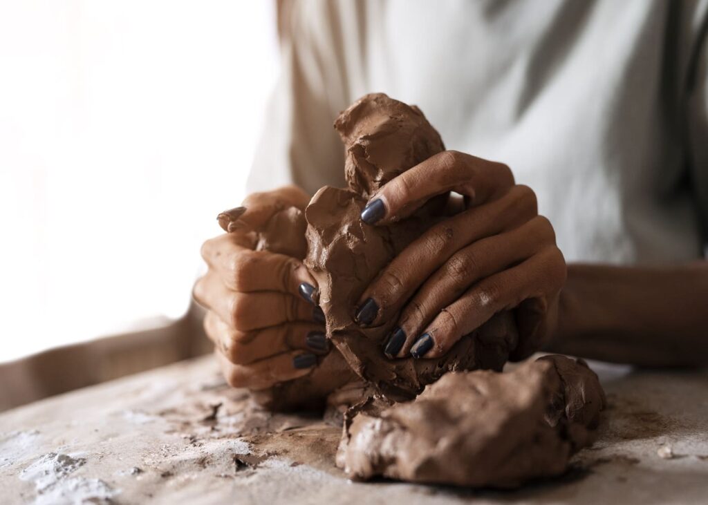 gros-plan-de-mains-de-femme-en-train-de-faire-une-sculpture-en-argile