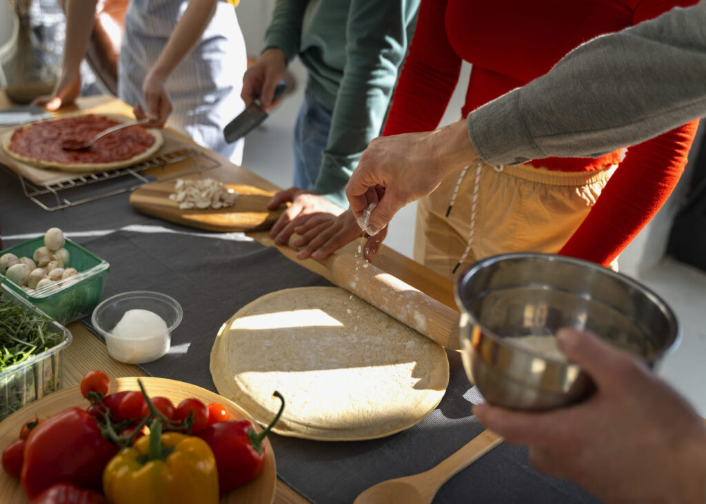 gros-plan-sur-les-mains-d-un-groupe-de-personnes-pendant-un-cours-de-cuisine