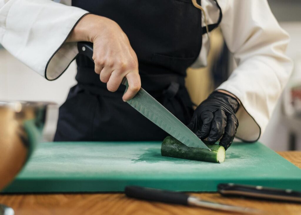 gros-plan-sur-une-femme-chef-de-cuisine-qui-coupe-un-concombre