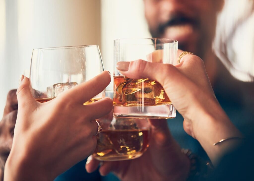 groupe-de-personnes-qui-trinquent-un-verre-de-whisky-a-la-main