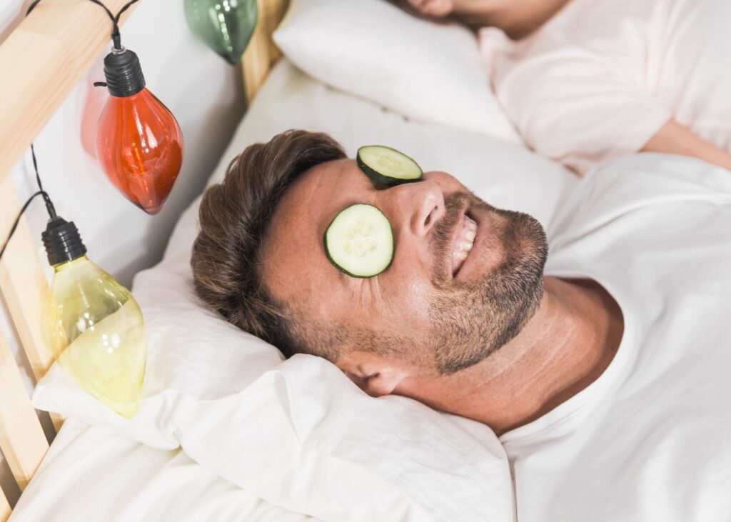 homme-allonge-qui-sourit-avec-des-concombres-sur-les-yeux.jpg