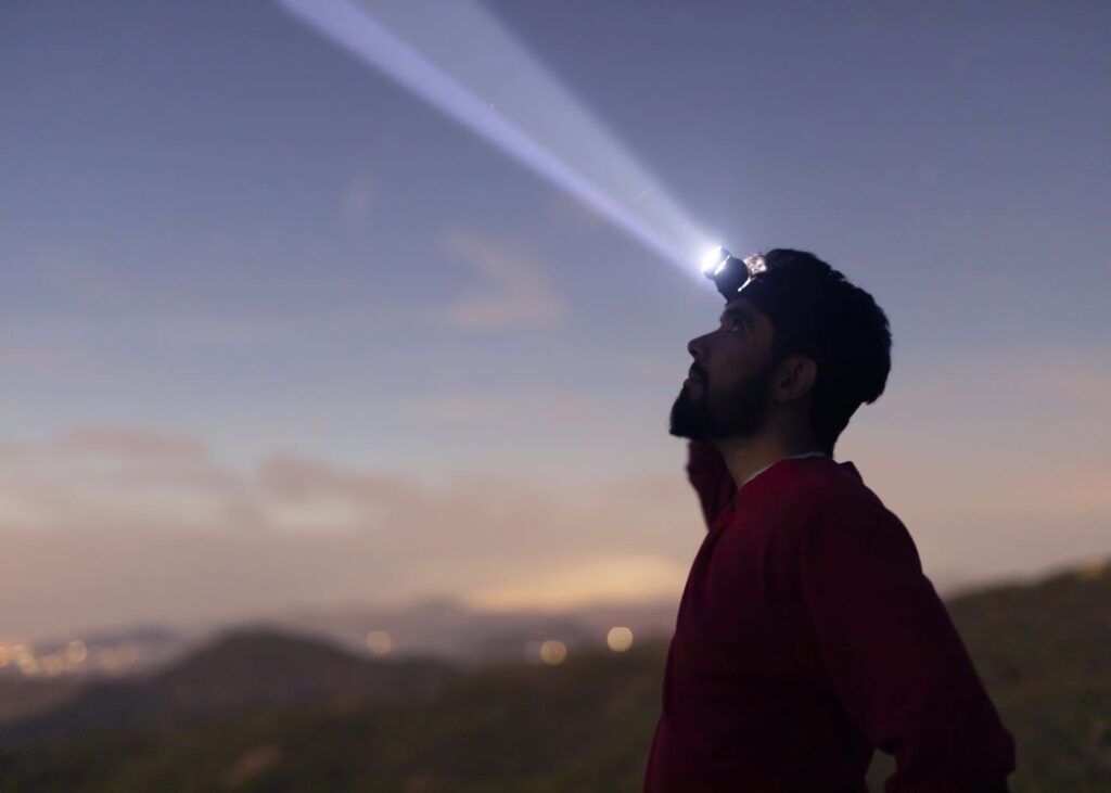 homme-avec-une-lampe-frontale-dans-la-nature-a-l-aube.jpg