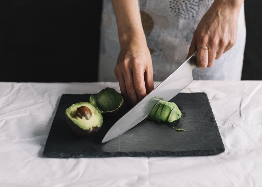 homme-qui-coupe-un-avocat-avec-un-couteau-professionnel