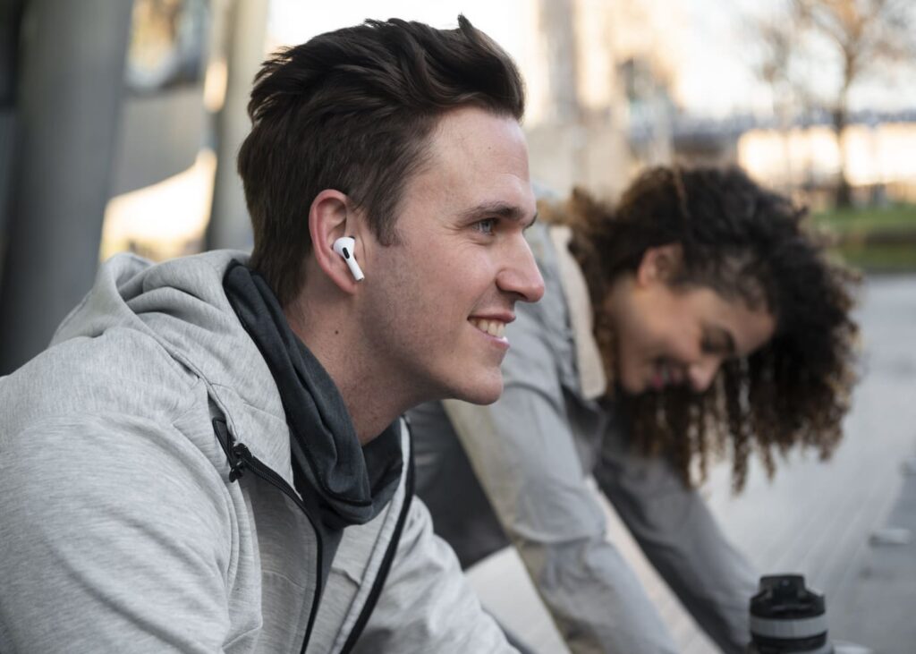 homme-qui-sourit-avec-des-ecouteurs-dans-les-oreilles.jpg