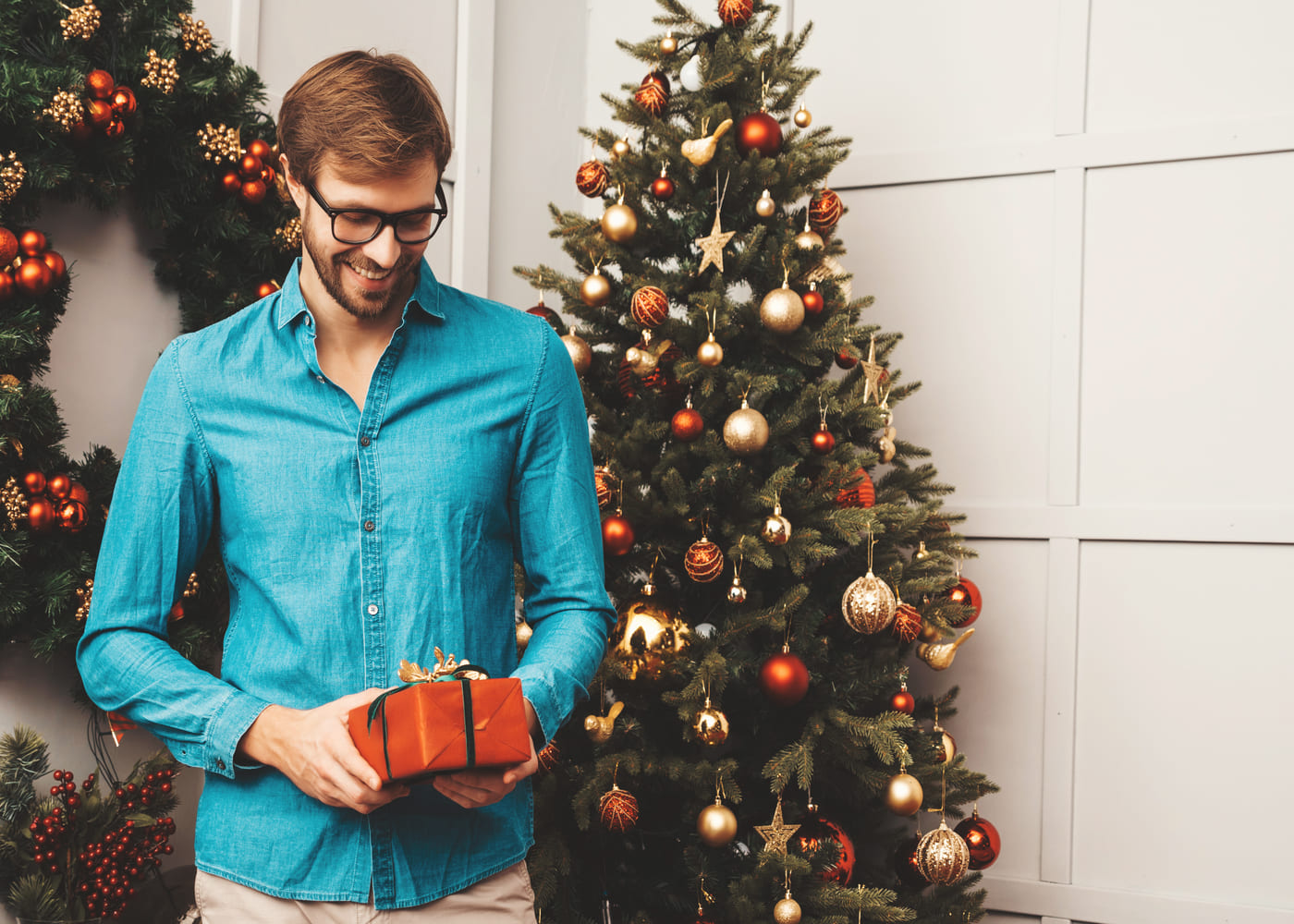 homme-qui-sourit-en-regardant-le-cadeau-de-noel