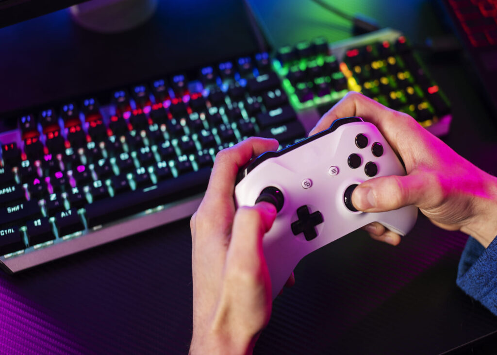 homme-qui-tient-une-manette-de-ps5-avec-clavier-lumineux