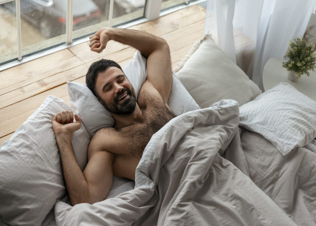 homme-torse-nu-qui-s-etire-dans-son-lit