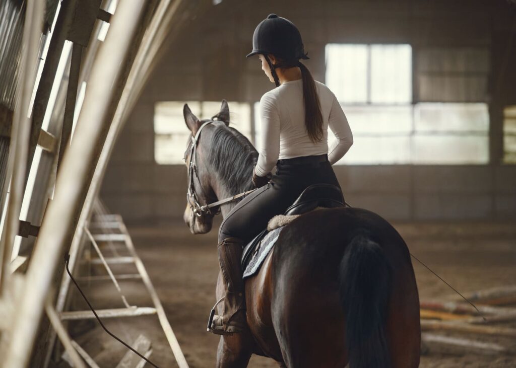 jeune-femme-qui-monte-a-cheval-dans-un-manege