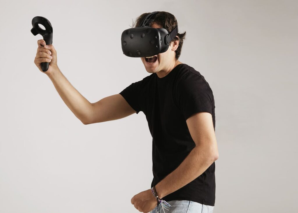 jeune-homme-qui-joue-a-un-jeu-avec-un-casque-vr-sur-la-tete-et-une-manette-dans-la-main