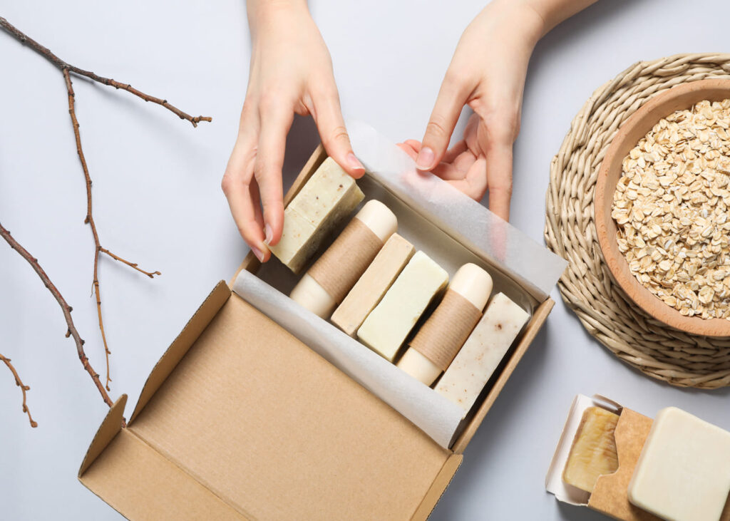 mains-de-femme-qui-place-un-savon-dans-un-coffret-rempli-de-produits-de-soin