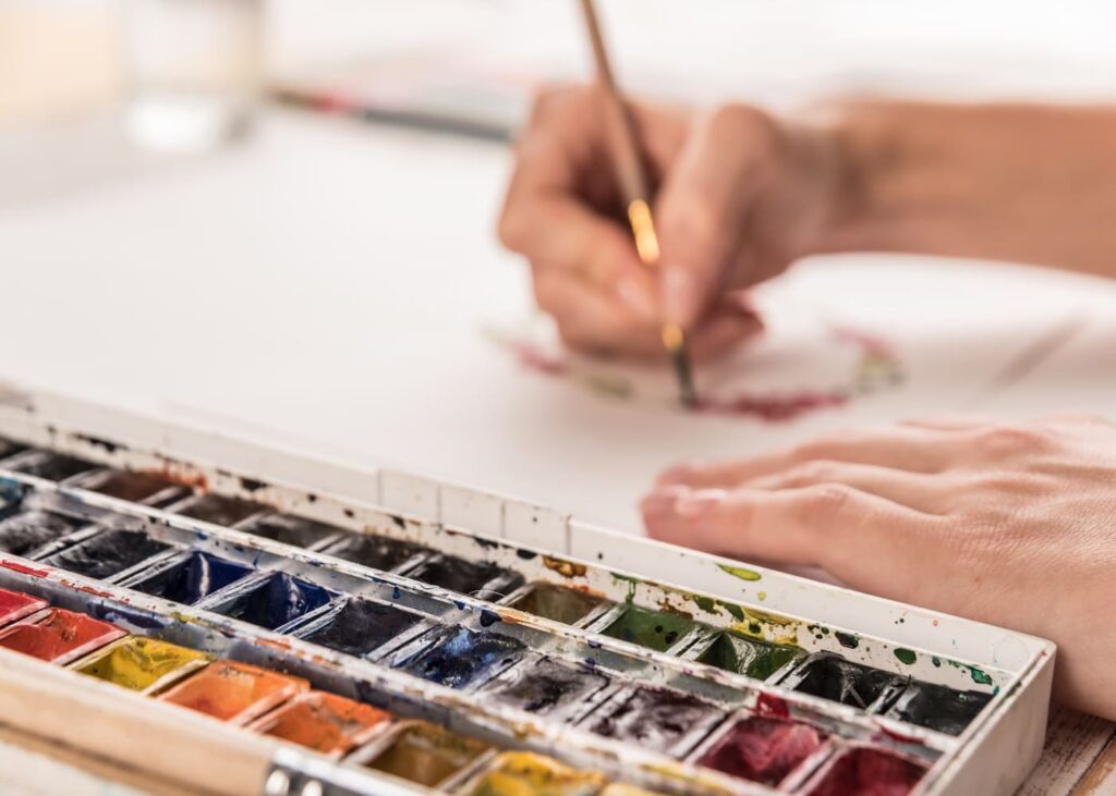 personne-qui-dessine-des-fleurs-avec-de-la-peinture-a-l-aquarelle