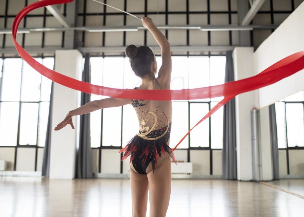 petite-fille-en-justaucorps-de-gymnastique-qui-fait-tourner-son-ruban.jpg