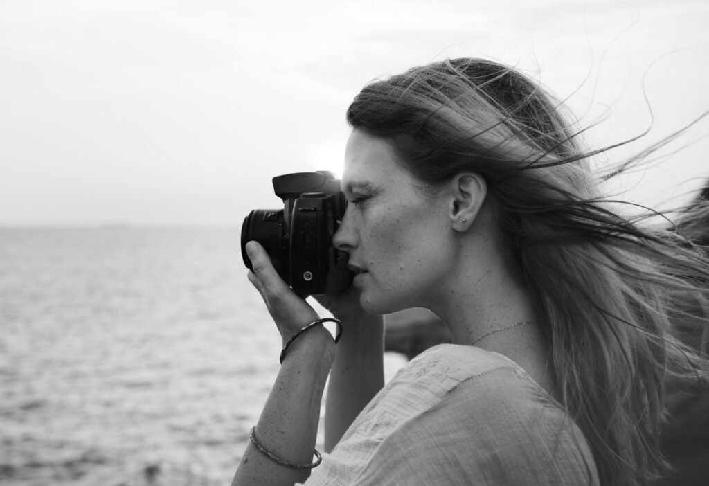 photo-en-noir-et-blanc-d-u-une-femme-qui-prend-une-photo-pres-de-la-mer