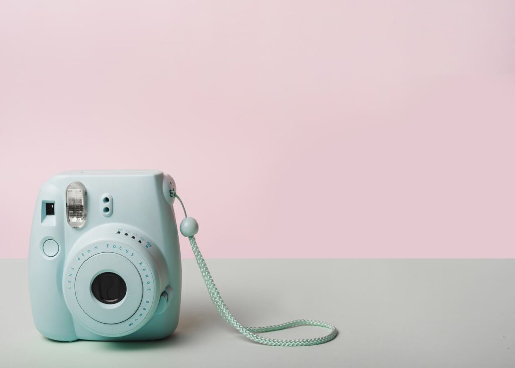 polaroid-vert-posé-sur-une-table-avec-fond-rose.jpg