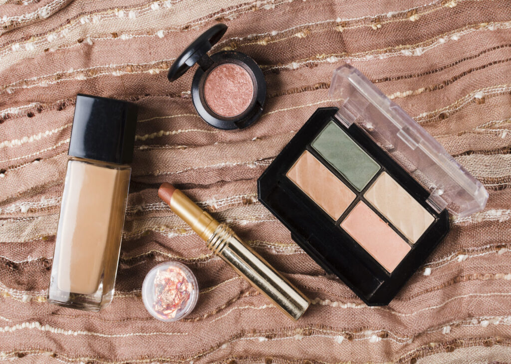 produits-de-maquillage-poses-sur-un-drap-rose