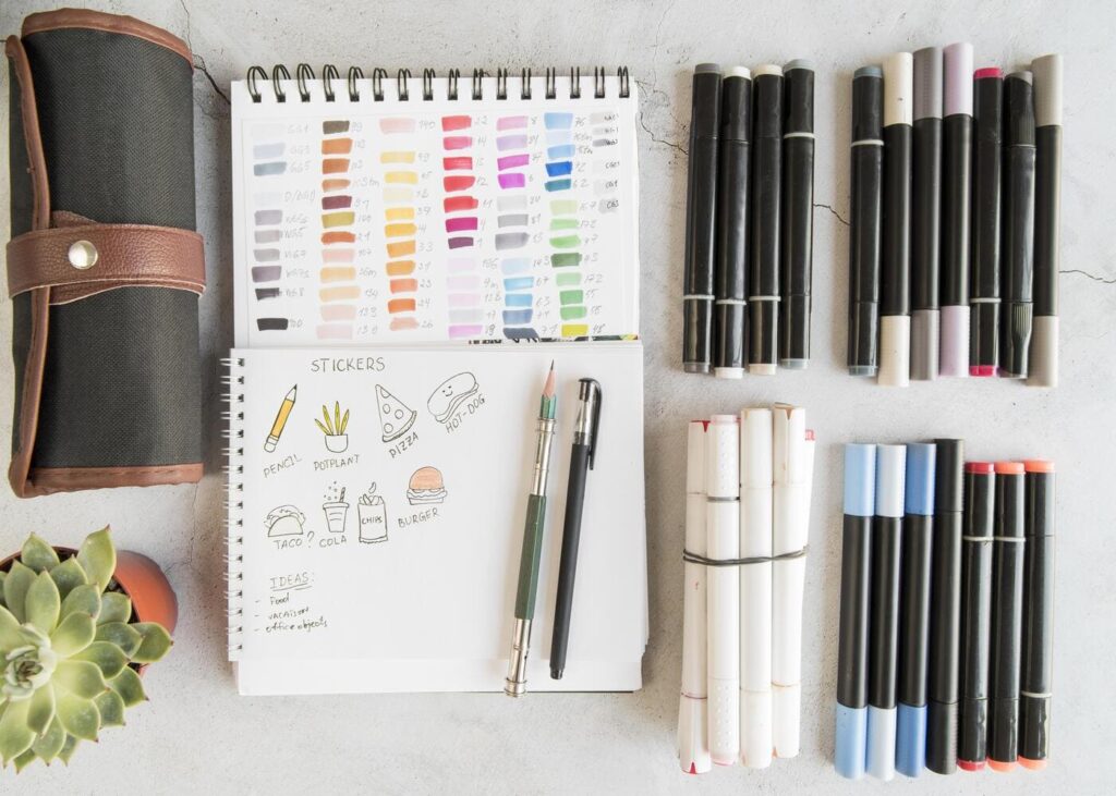 vue-du-dessus-d-un-carnet-a-dessins-avec-des-feutres