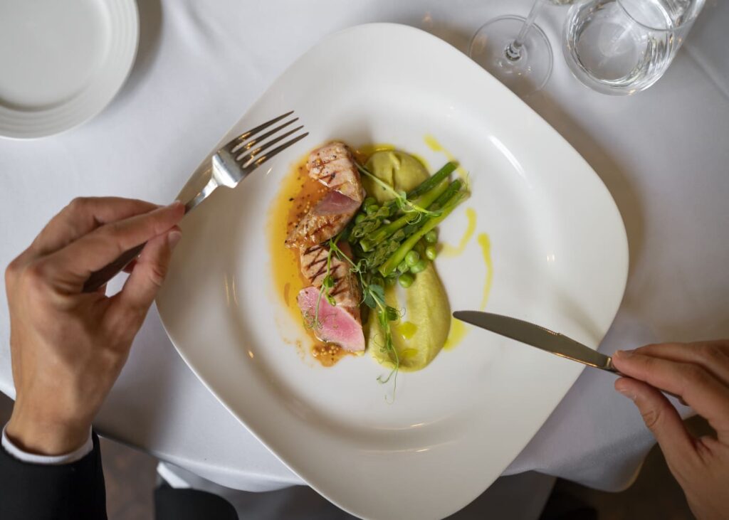 vue-du-dessus-d-un-homme-en-train-de-deguster-un-plat-raffine-dans-un-restaurant