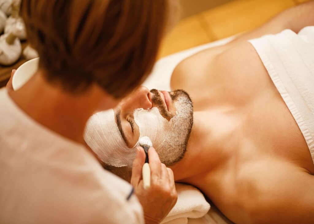 femme-qui-pose-un-masque-pour-le-visage-a-un-homme-dans-un-institut