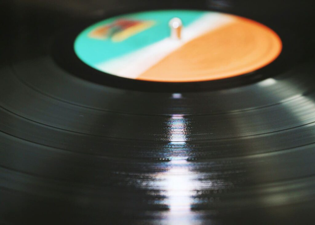 gros-plan-d-un-vinyle-noir-avec-le-centre-orange-blanc-et-vert