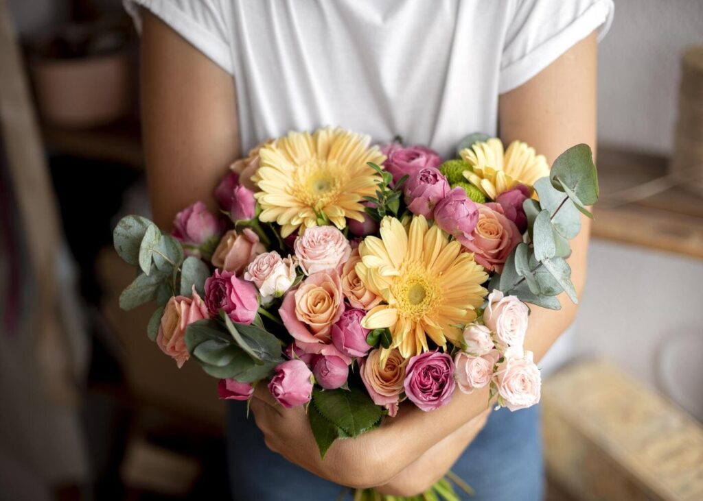 gros-plan-d-une-femme-qui-tient-un-bouquet-de-fleurs-dans-les-mains