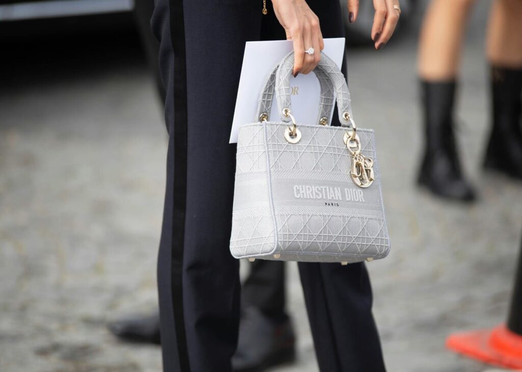 gros-plan-d-une-femme-qui-tient-un-sac-a-main-en-cuir-blanc-dior