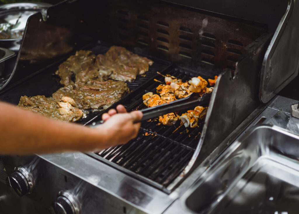gros-plan-d-une-main-d-homme-qui-cuit-de-la-viande-au-barbecue