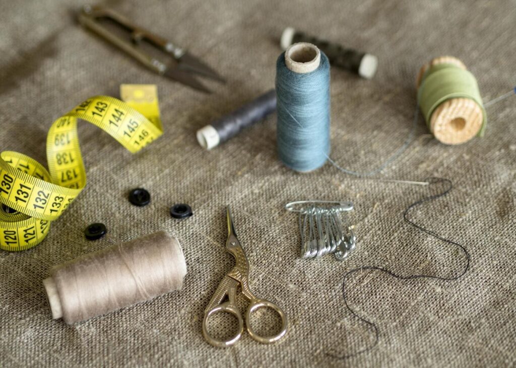 gros-plan-sur-du-materiel-de-couture-pose-sur-une-couverture-beige