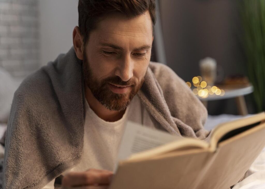 homme-avecun-plaid-sur-les-epaules-qui-lit-un-livre.jpg