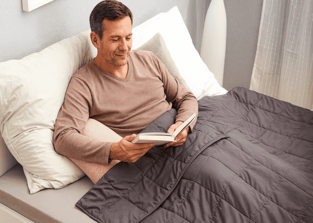 homme-de-40-ans-qui-lit-dans-son-lit-avec-une-couverture-lestee