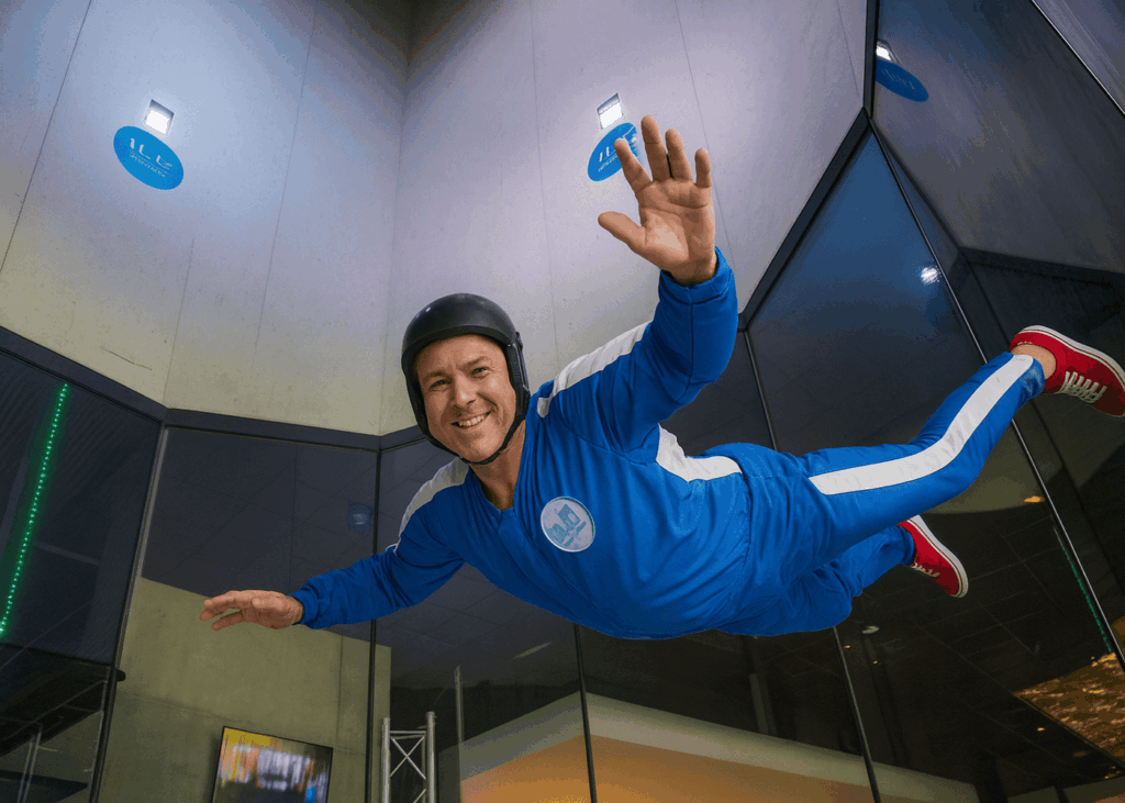 homme-de-40-ans-qui-sourit-en-faisant-un-simulateur-de-chute-libre-en-soufflerie