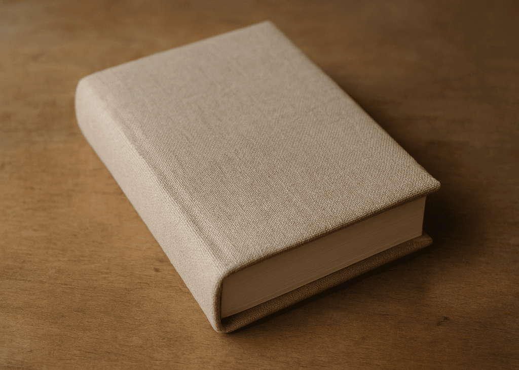 livre-avec-une-couverture-en-tissu-beige-pose-sur-une-table
