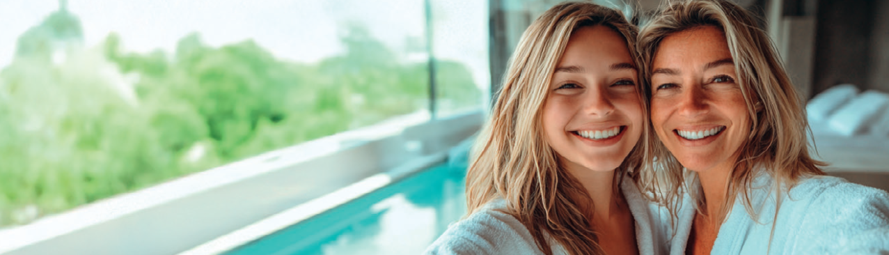 une mere et sa fille qui prennent un selfie devant une piscine au spa